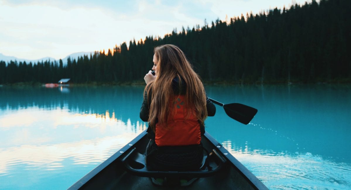 A person sitting in front of a body of water