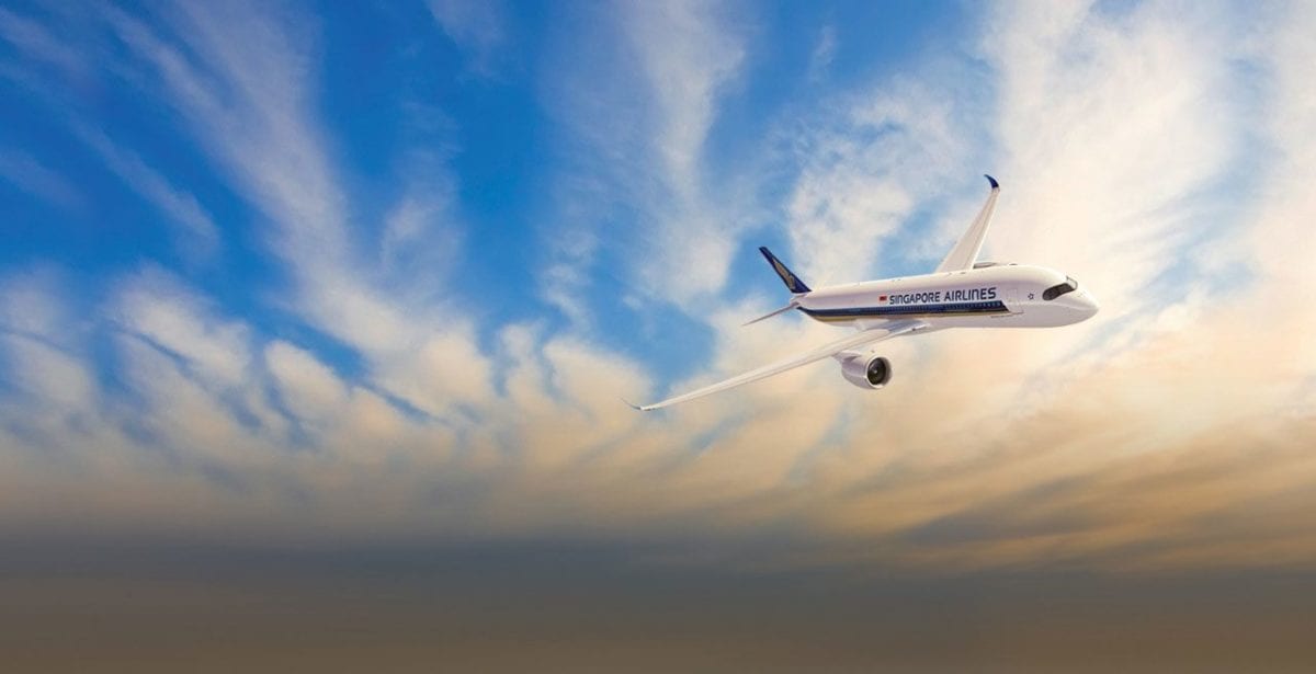 A large passenger jet flying through a cloudy blue sky