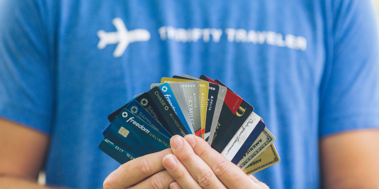 Man in Thrifty Traveler t-shirt holding credit cards