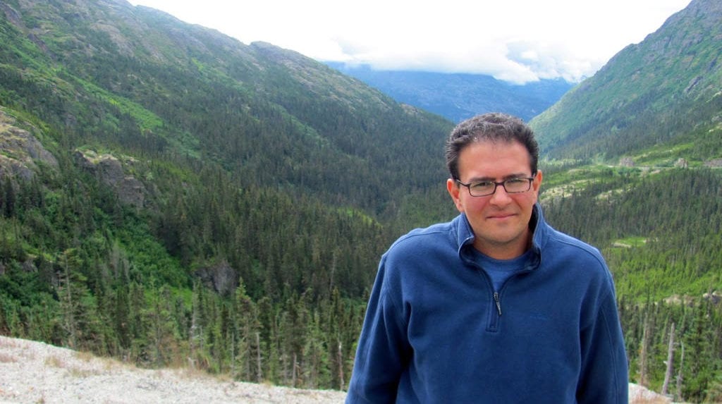 Michael Russo standing in front of a mountain