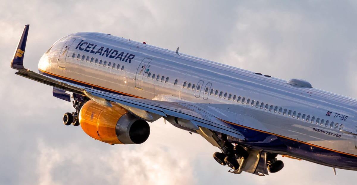 A large passenger jet flying through a cloudy blue sky
