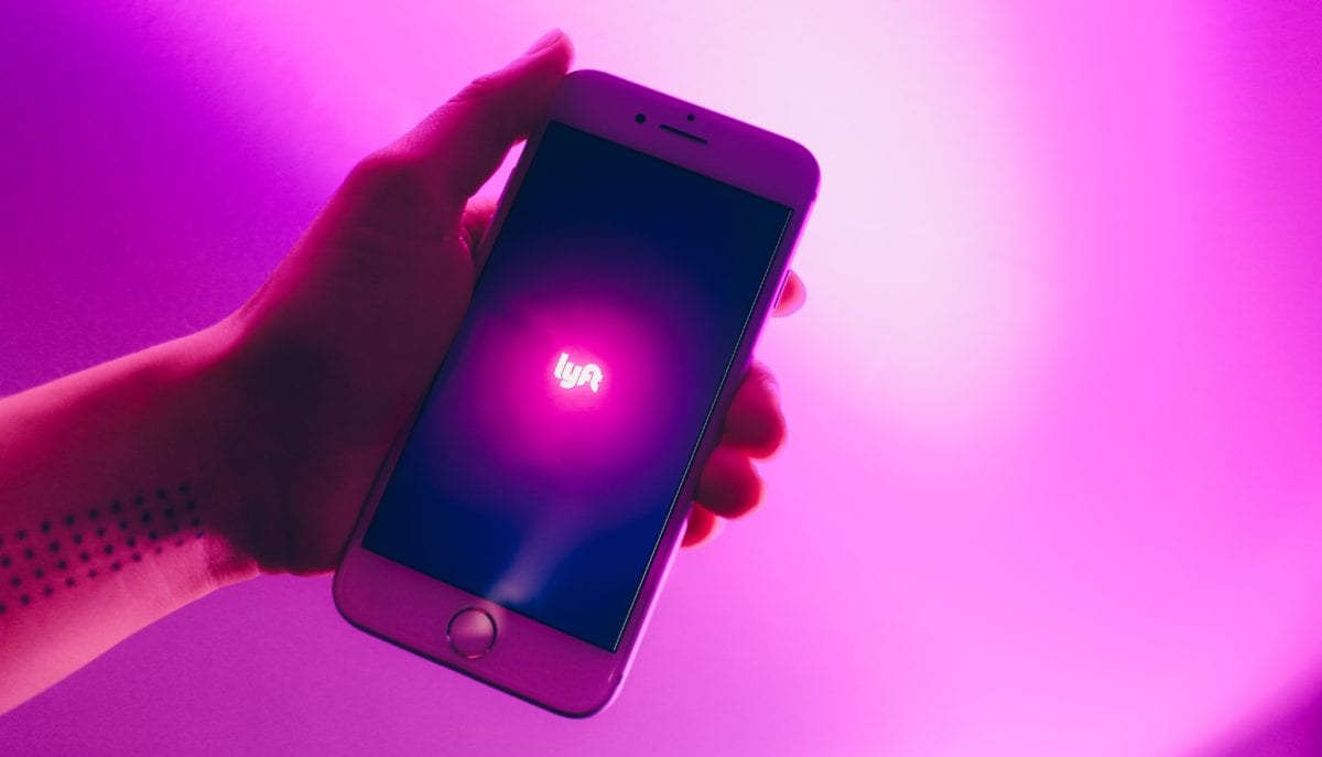 a person holding a phone with the lyft app open