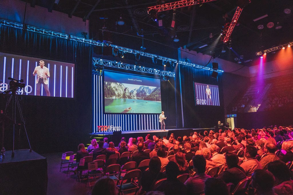 A person standing on a stage in front of a crowd