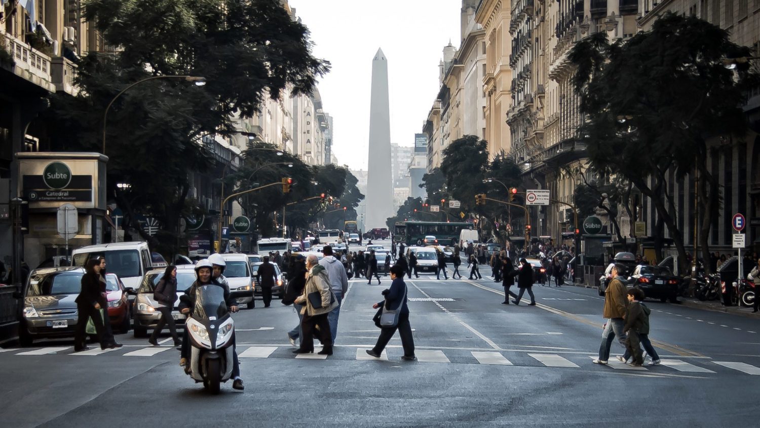 A group of people walking down a busy city street