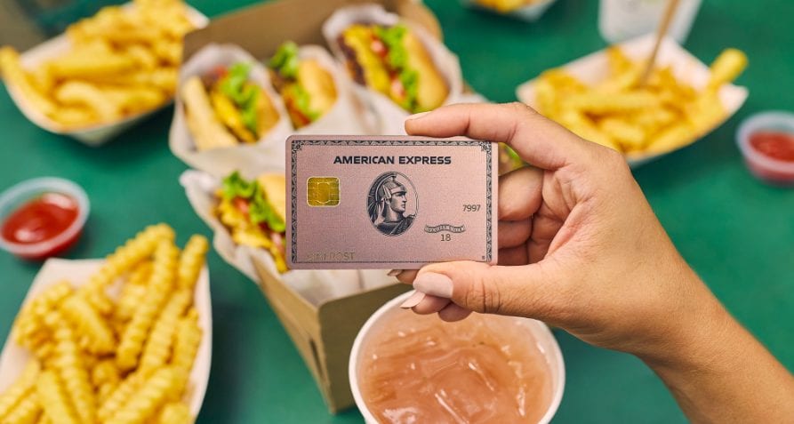 A person holding an American Express Gold Card