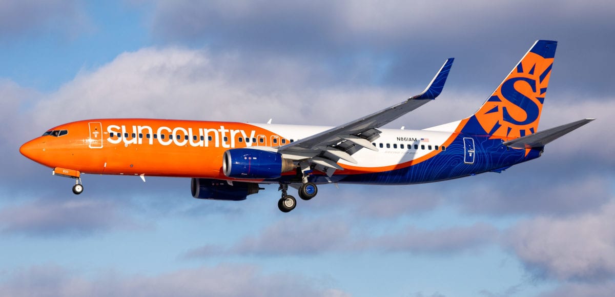 a sun country airplane flying midair