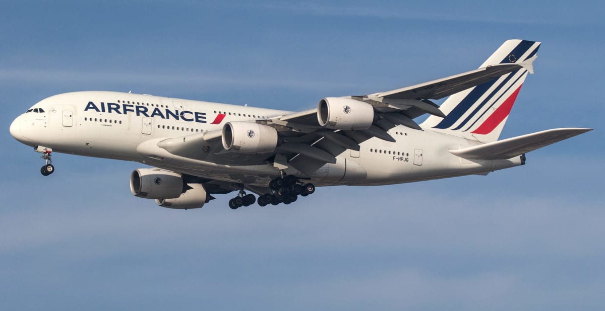 A large passenger jet flying through a cloudy blue sky