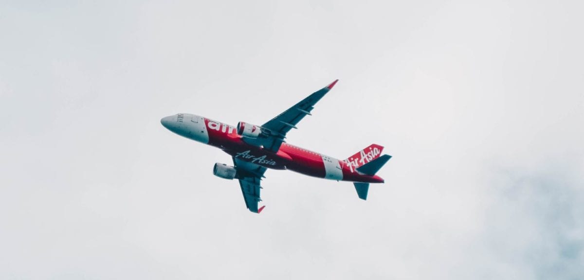 A large passenger jet flying through a cloudy blue sky