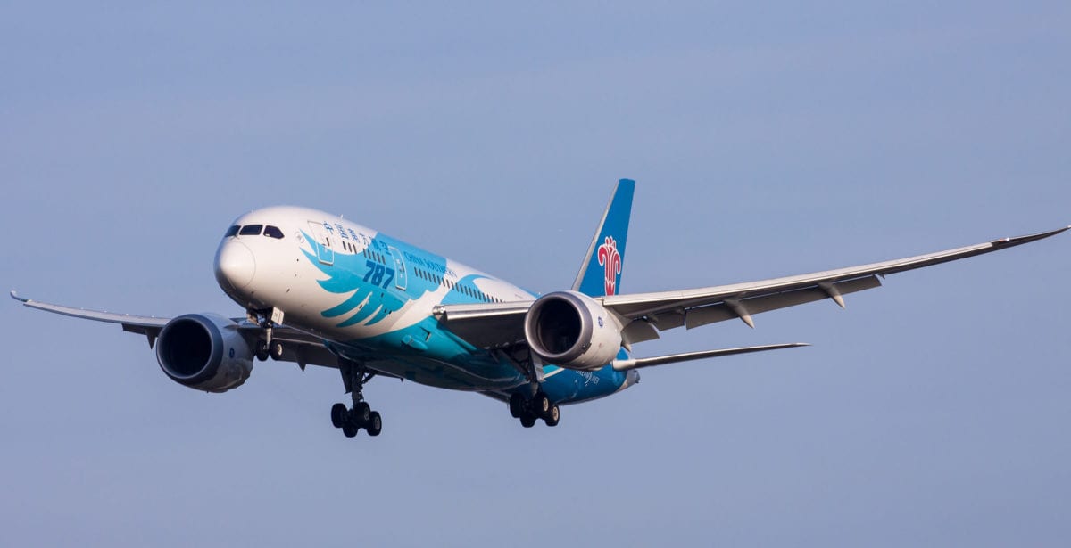 A large passenger jet flying through a blue sky