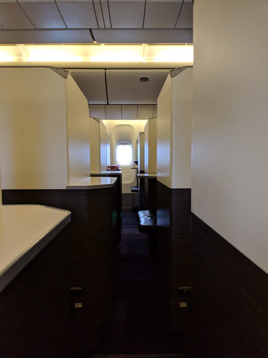 a narrow walkway between business class suites to the aisle