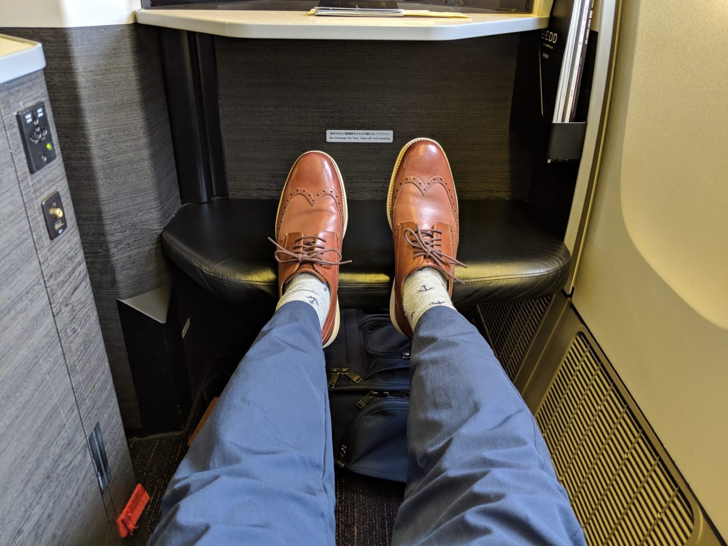 legs outstretched onto an ottoman on a plane