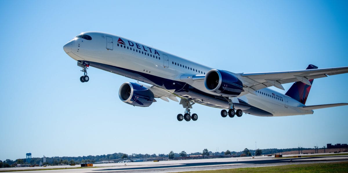 A large passenger jet flying through a blue sky