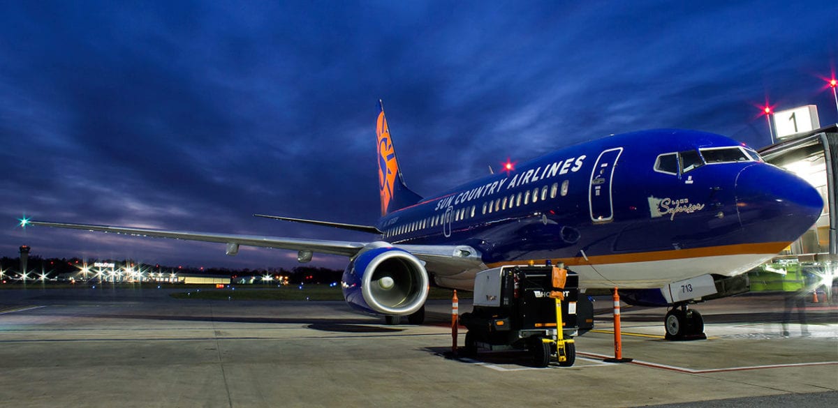 A large Sun Country jet sitting on top of a runway