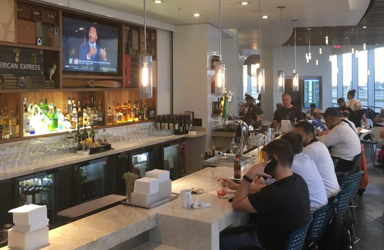 bar with patrons lining up inside of an airport lounge