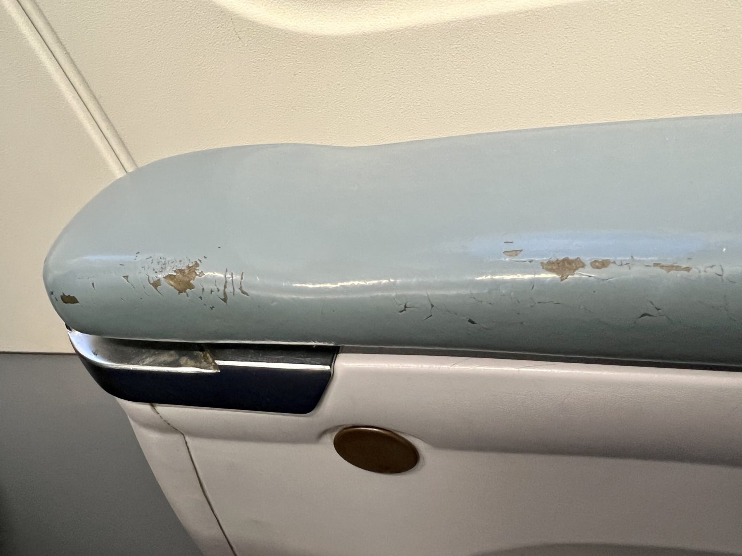 scratches on the armrest of an airline seat