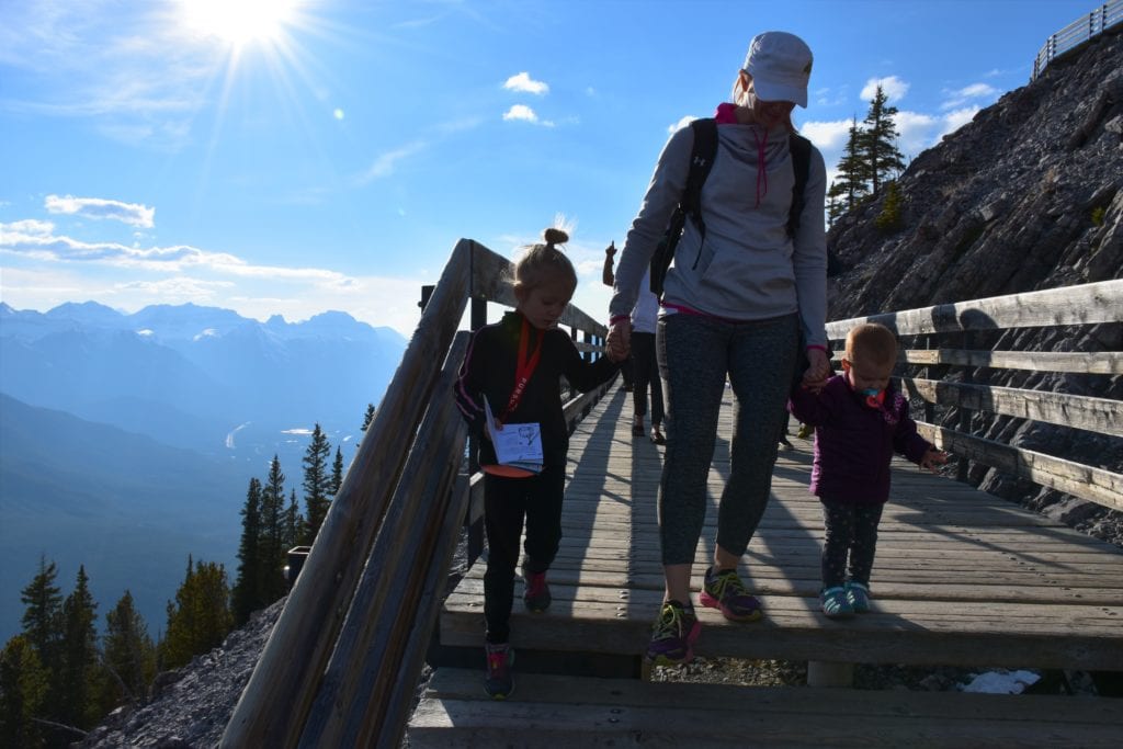 a woman and children walking down a flight of stairs