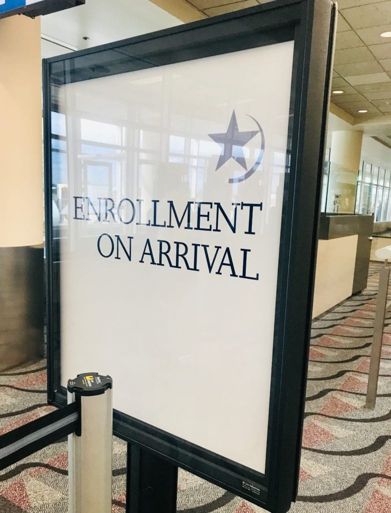 enrollment on arrival sign in an airport