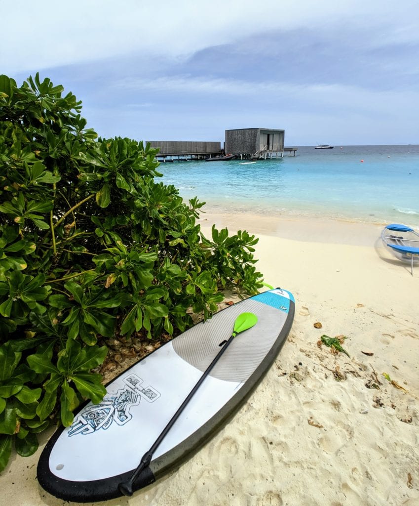 A beach with a surf board in the sand