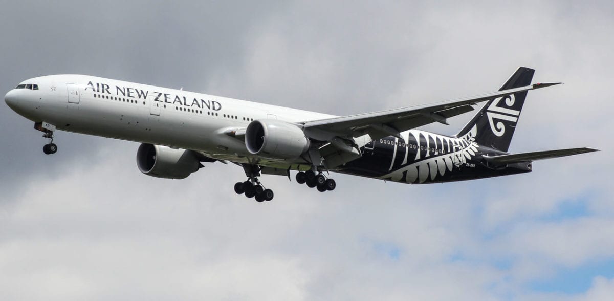 A large passenger jet flying through the air on a cloudy day