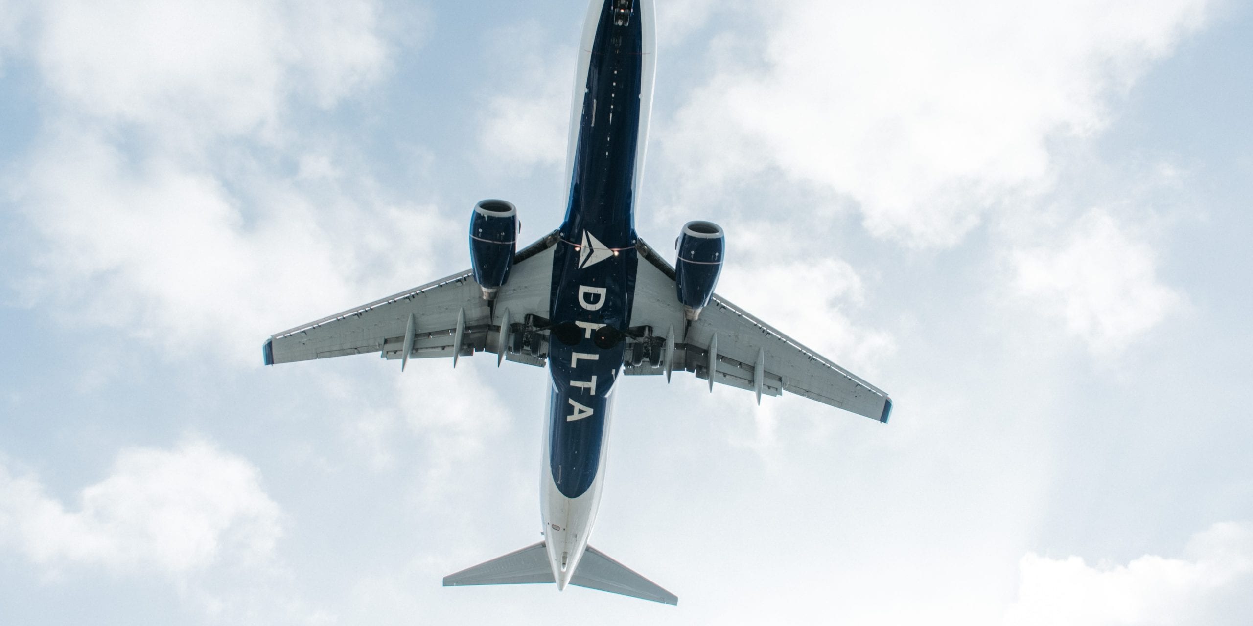 A large passenger jet flying through a cloudy blue sky