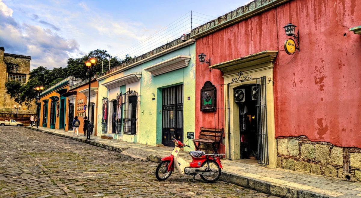 A scooter parked in front of a brick building in Oaxaca