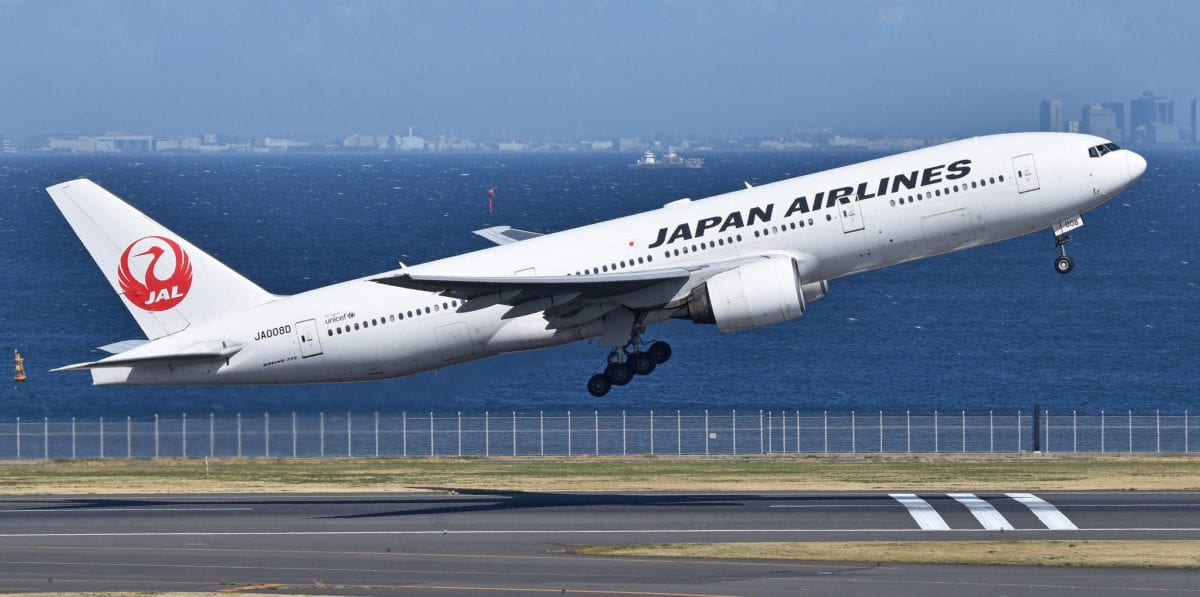 A large japan airlines passenger jet sitting on top of a runway