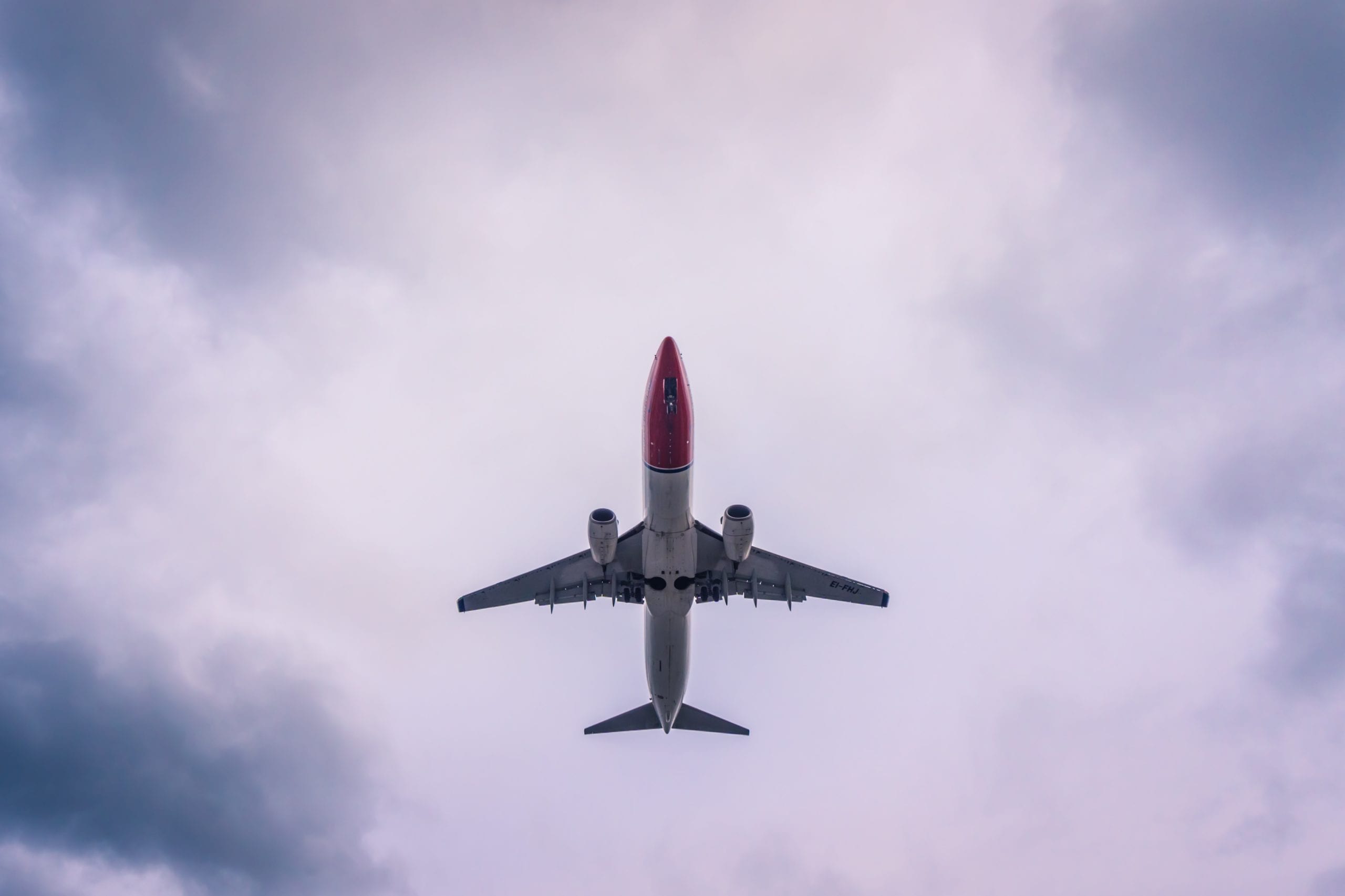 A jet flying through a cloudy blue sky