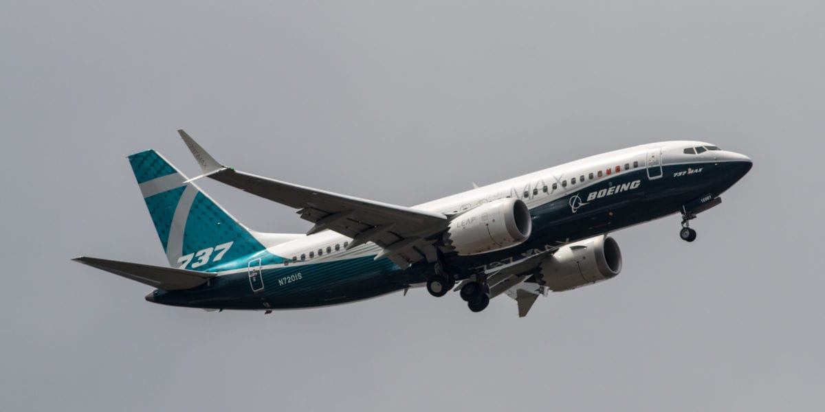A large passenger jet flying through a cloudy blue sky