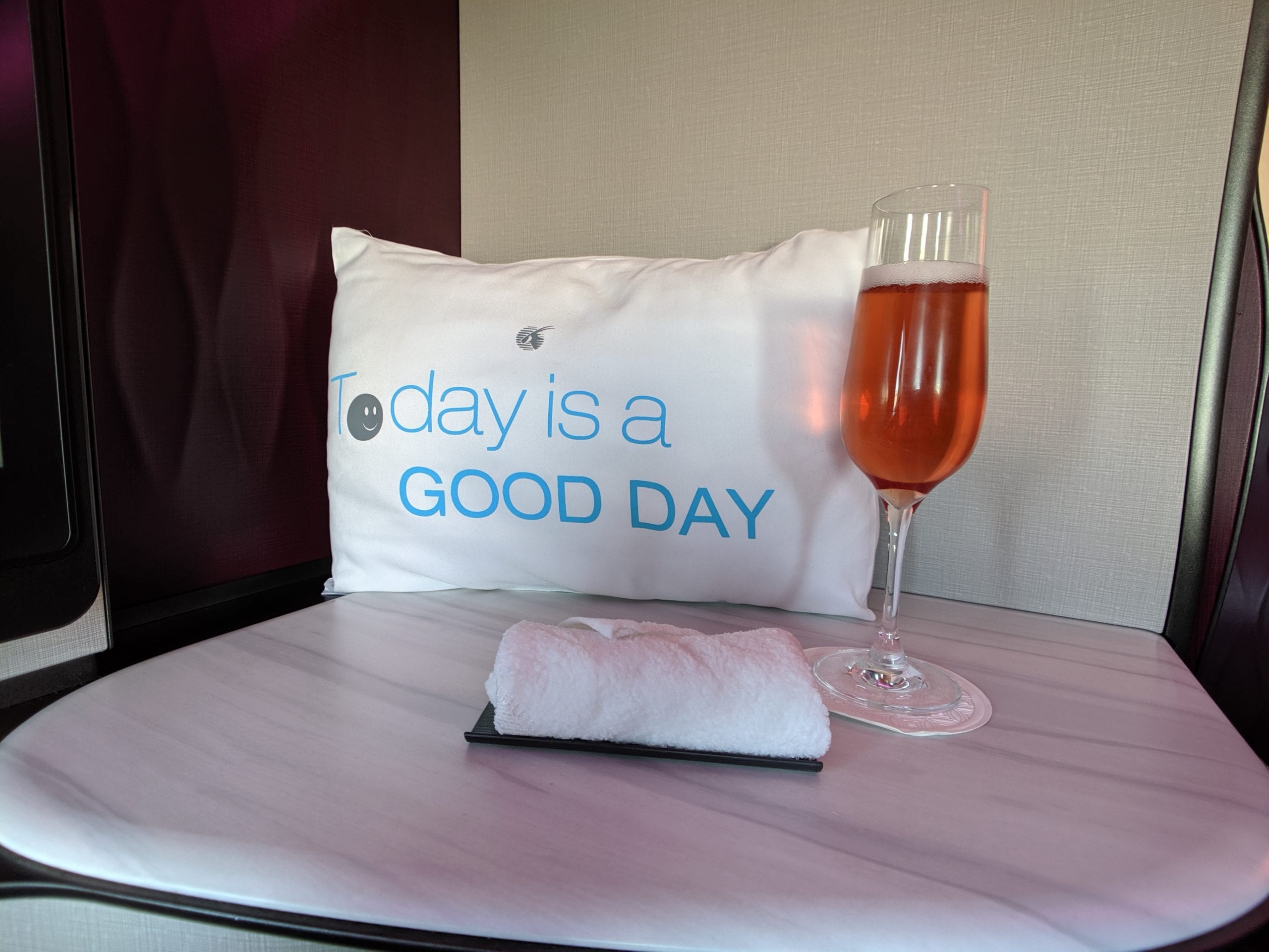 A glass of wine sitting on top of a table, with Qatar Airways