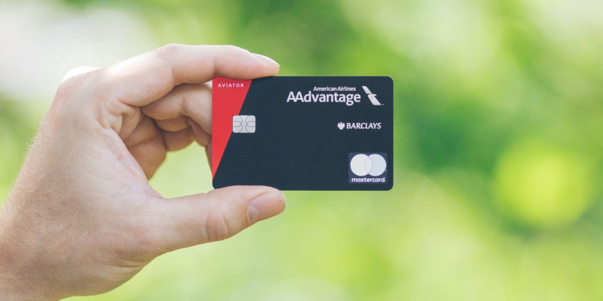 a man holding a Barclays American Airlines Aadvantage Aviator Red card