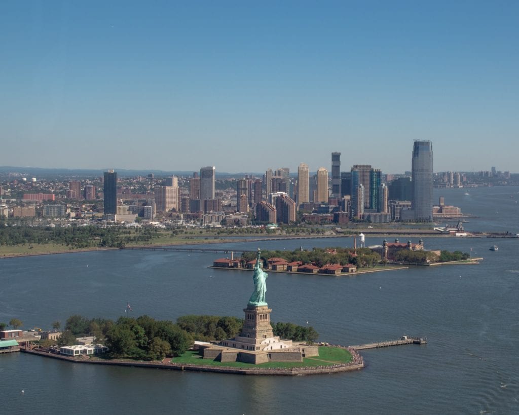 the statue of liberty with the new york skyline in the background
