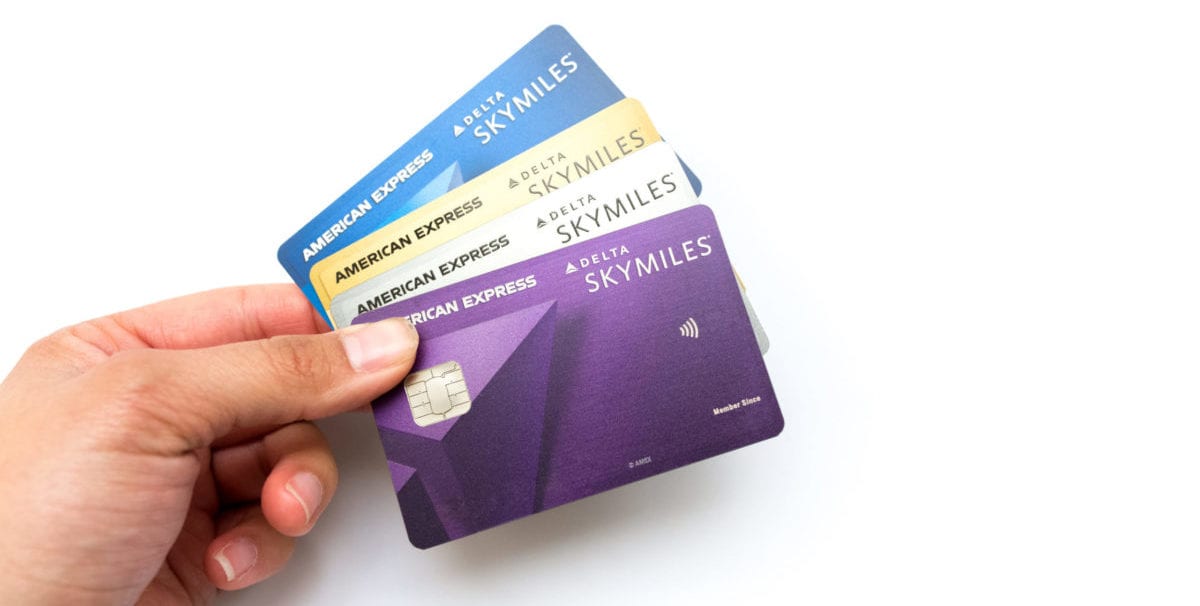 A hand holding the delta blue, delta gold, delta platinum, delta reserve cards