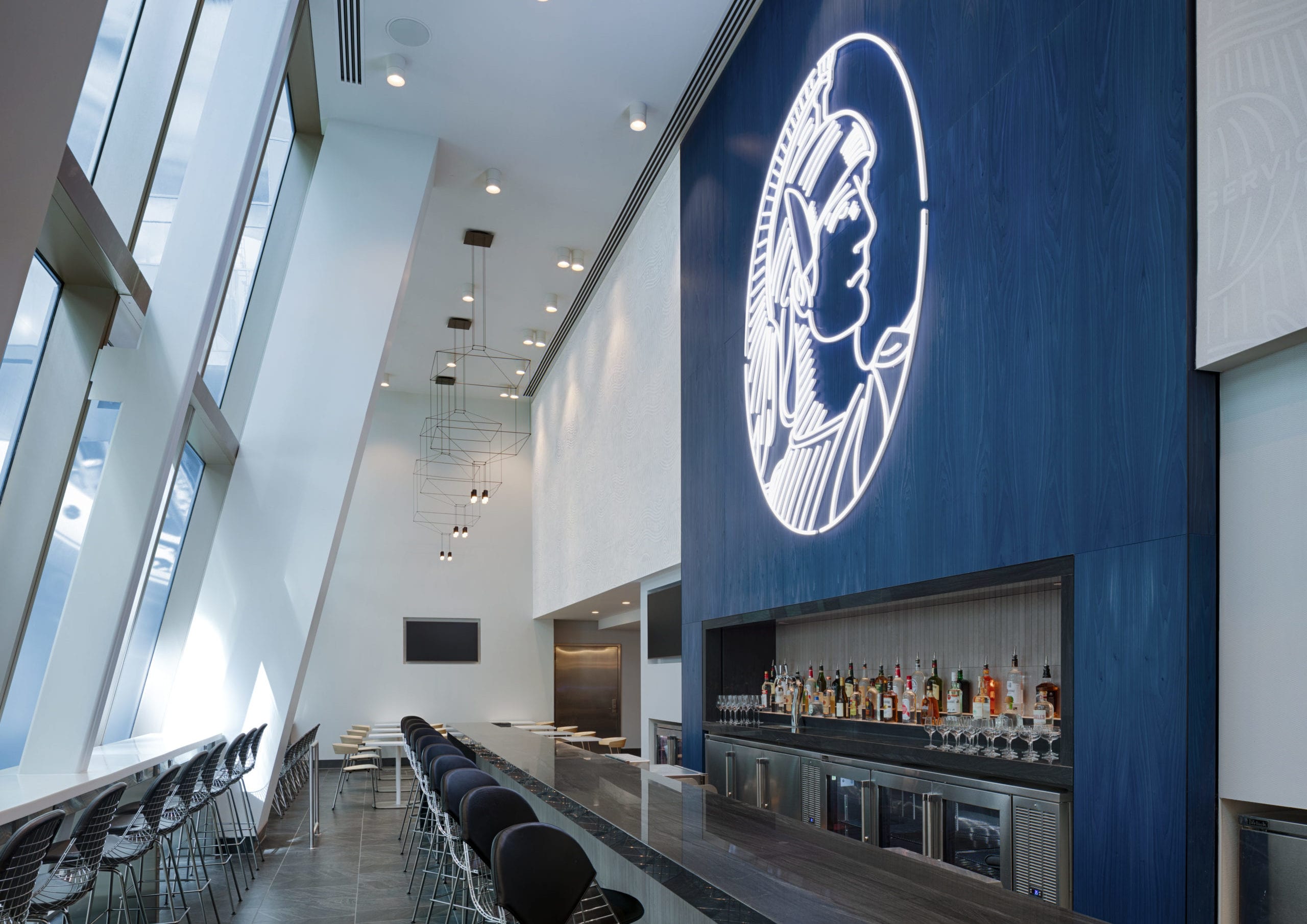 large bar inside of an airport lounge with an amex logo overhead