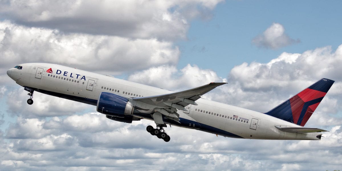 A large passenger jet flying through a cloudy blue sky