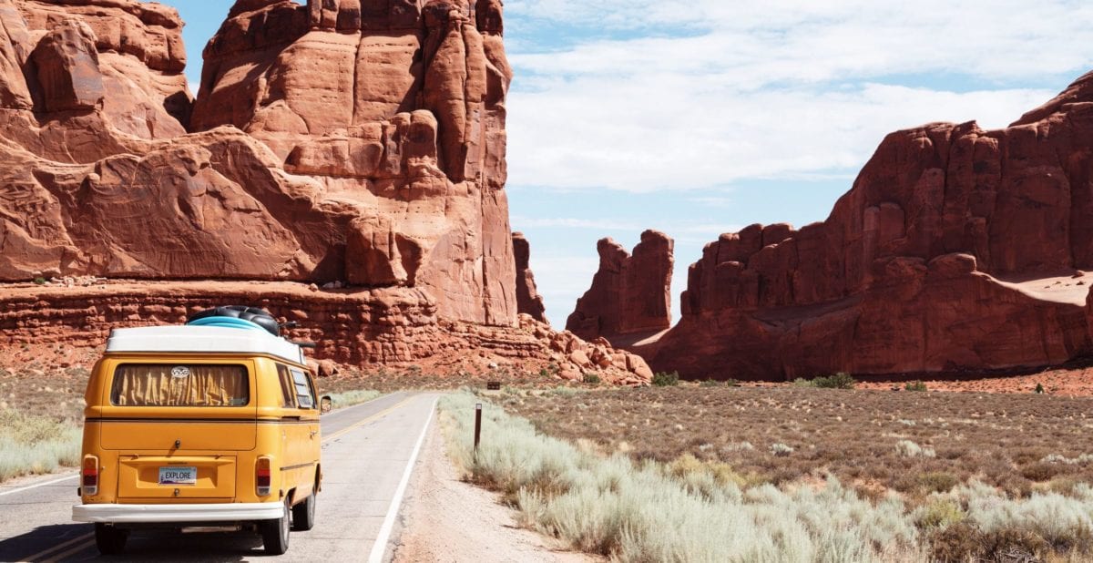 A bus parked in front of a rocky mountain