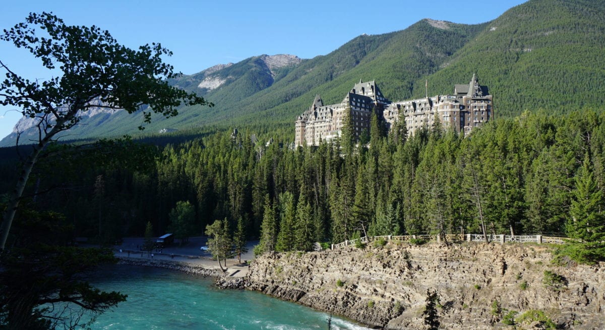 A view of a lake surrounded by trees and a mountain in the background