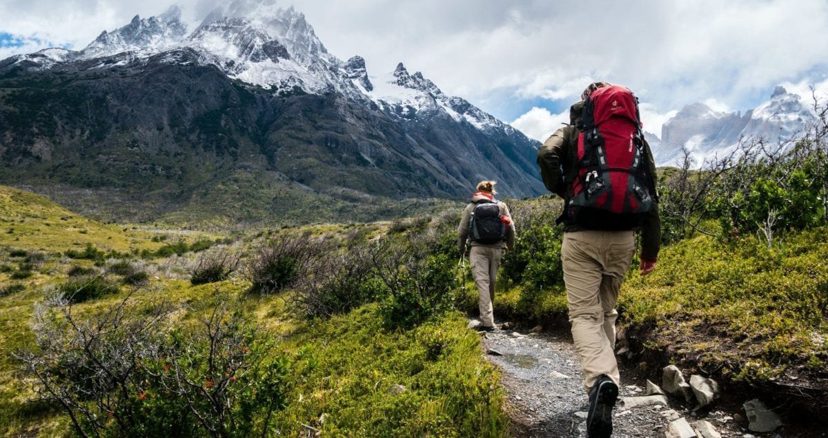 A man and woman standing in front of a mountain
