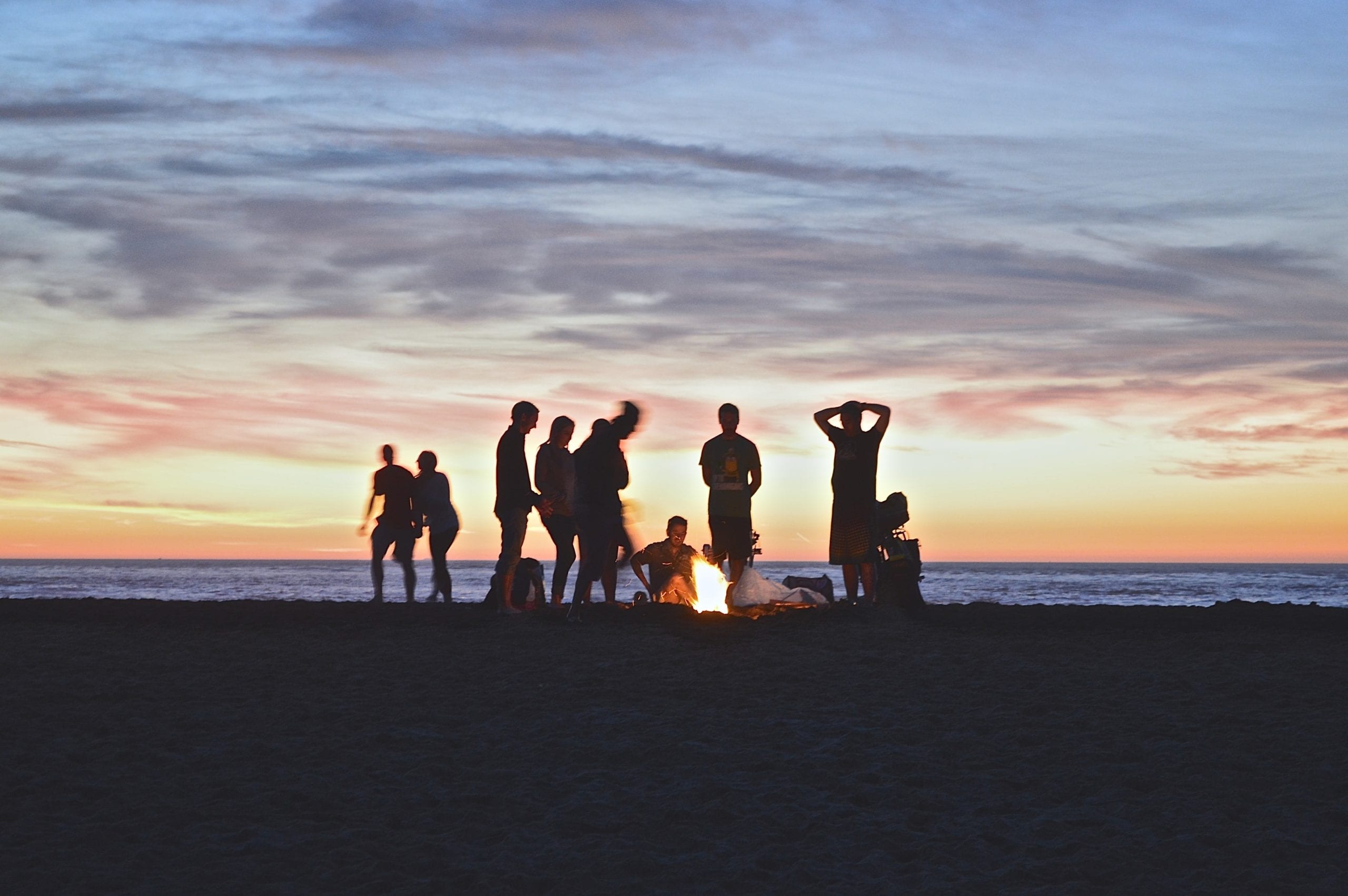 A group of people on a beach near a body of water