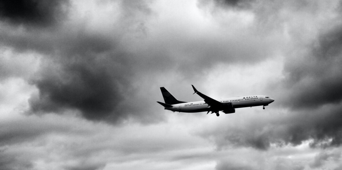 A large passenger jet flying through a cloudy sky