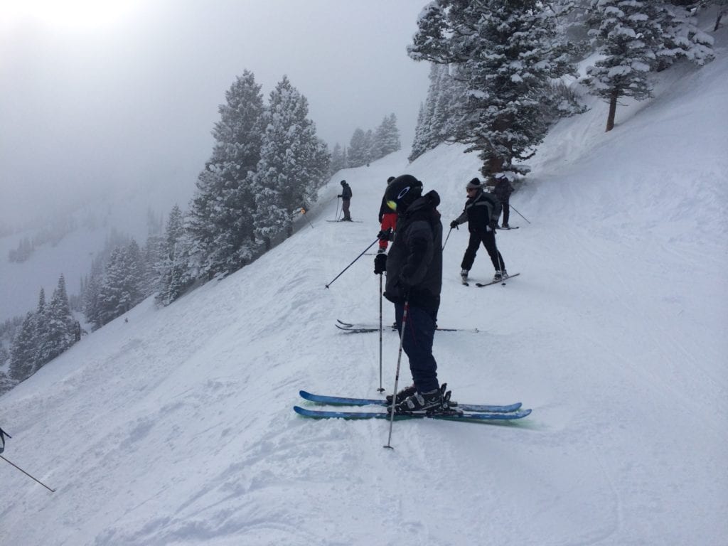 A man riding skis down a snow covered slope