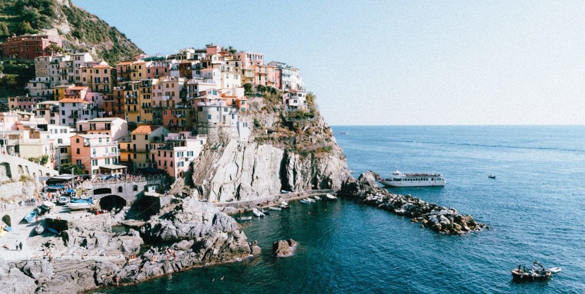 A large body of water with Cinque Terre in the background