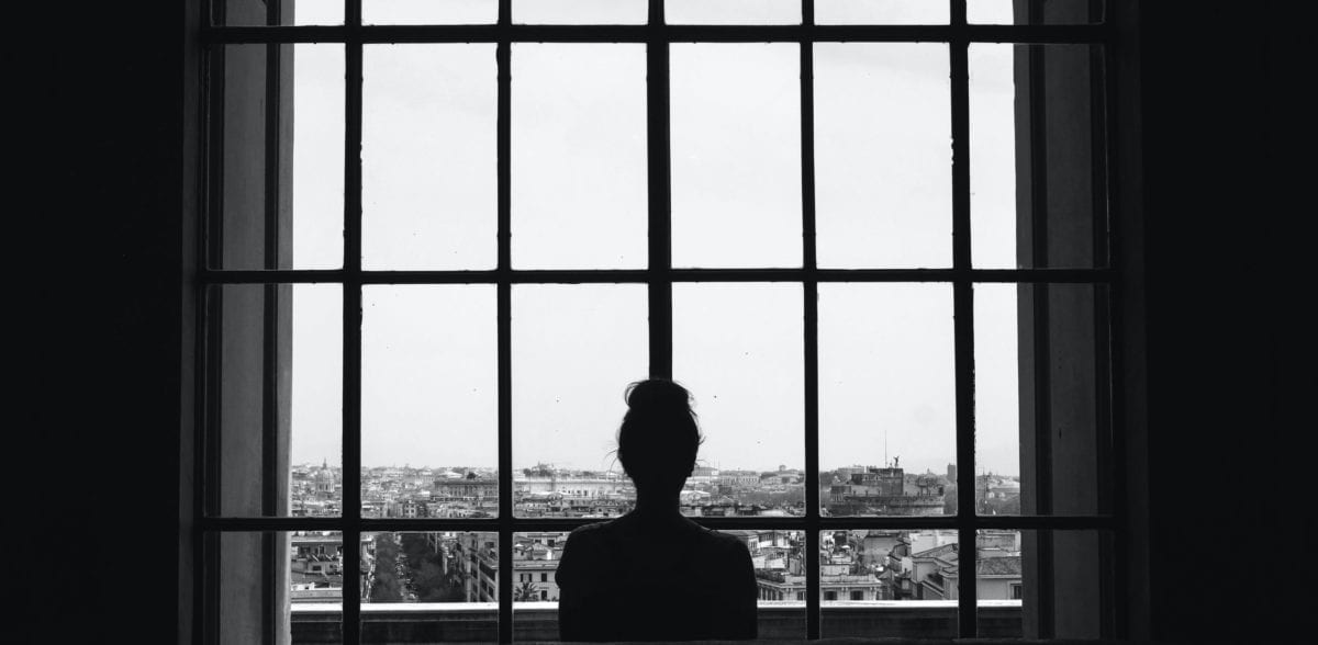 A person standing in front of a window