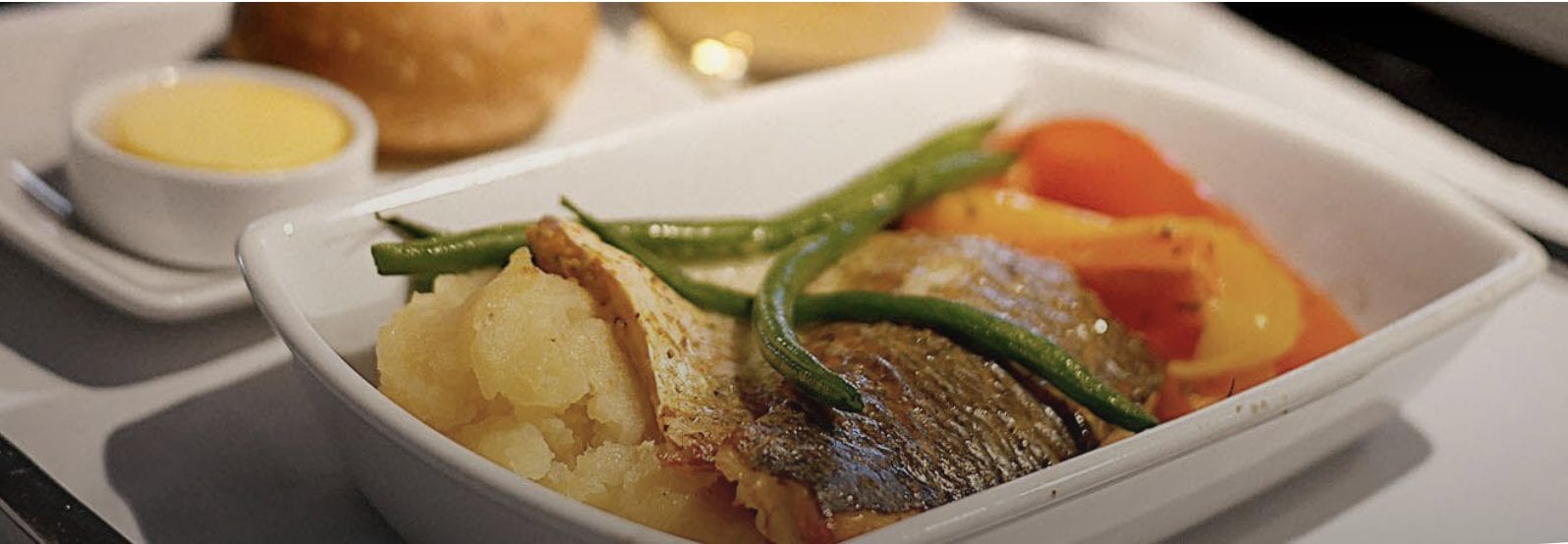 A close up of a bowl of food on a plate, with Business class and Airline