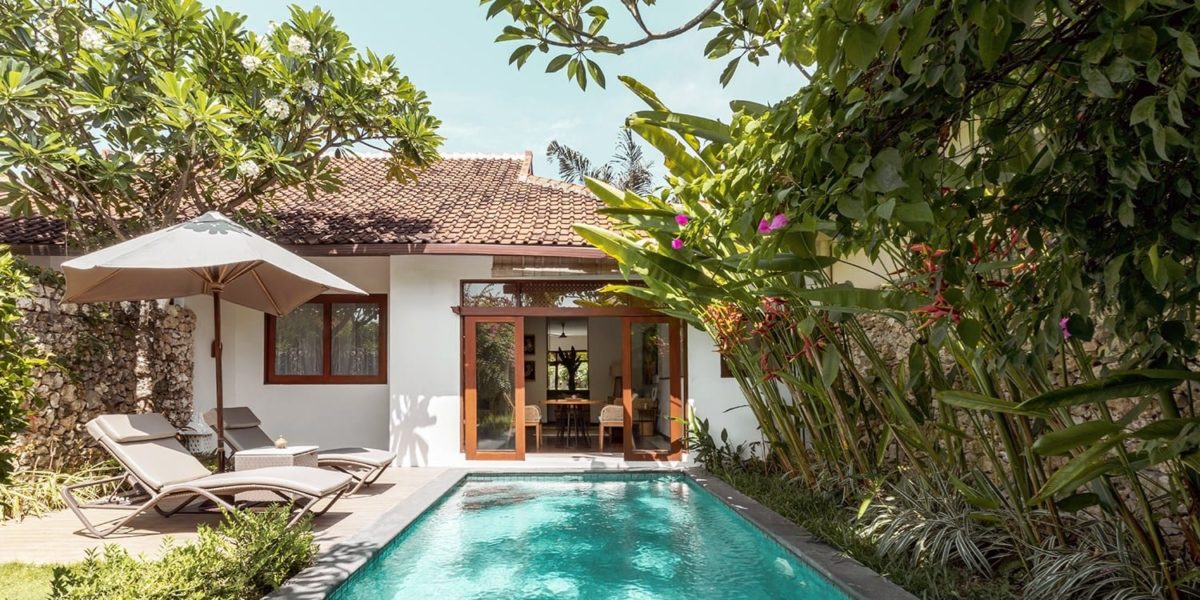 A house with a pool in front of a building