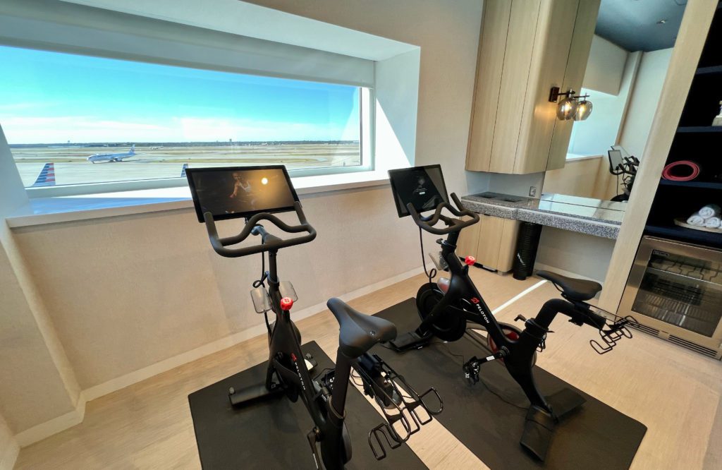 two peloton exercise bikes with a window looking out at the airport tarmac