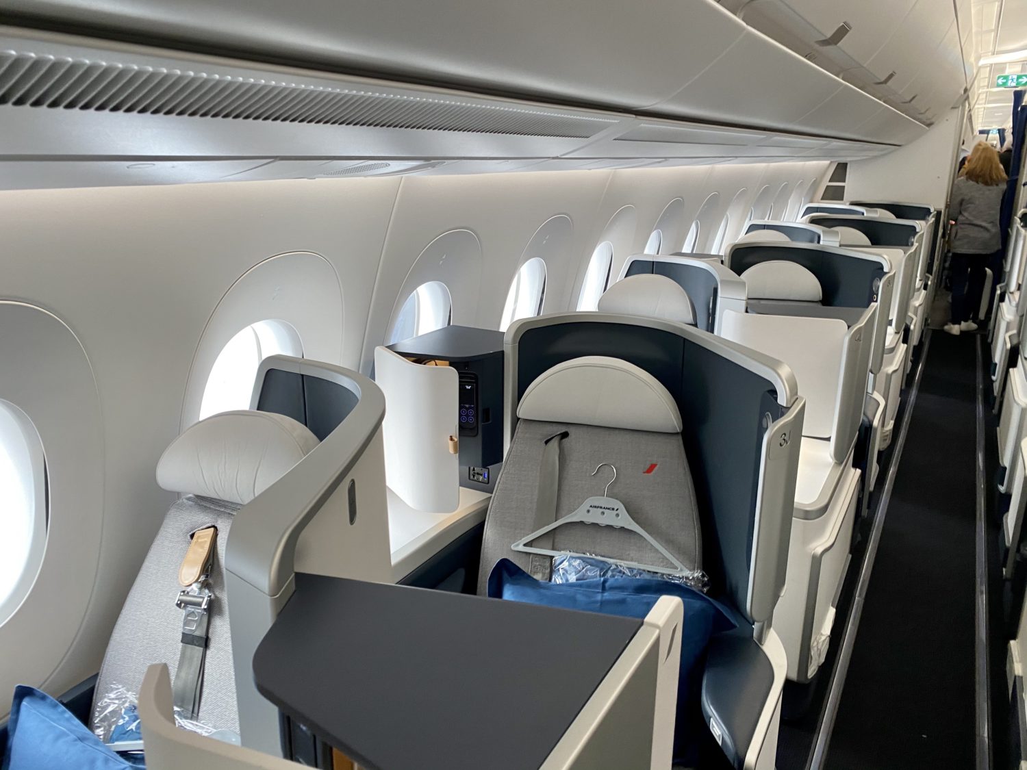 air france business class cabin with blue pillows and hangers on the seat