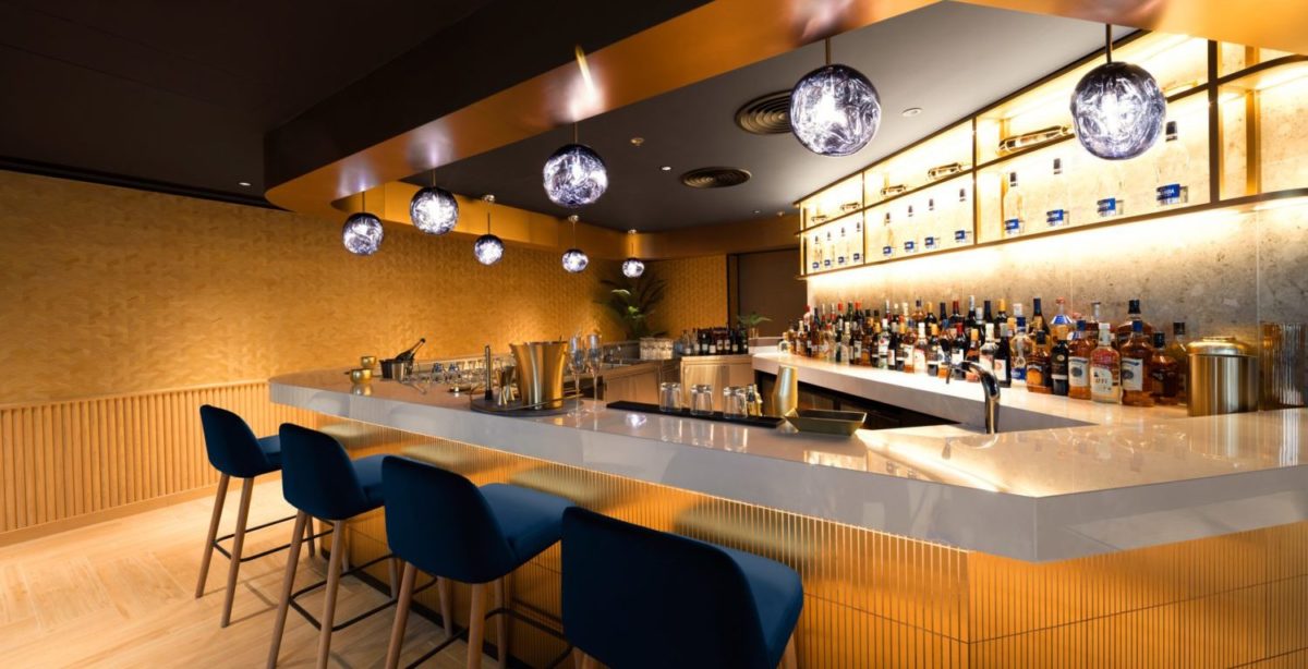 a bar with four blue velvet bar stools and disco balls