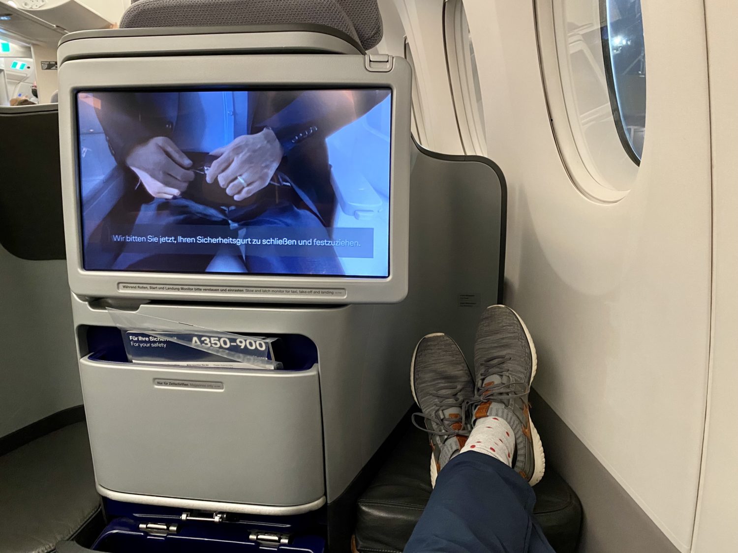legs outstretched in a business class seat