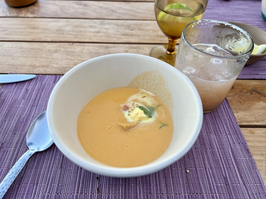 a bowl of soup sitting on a purple placemat