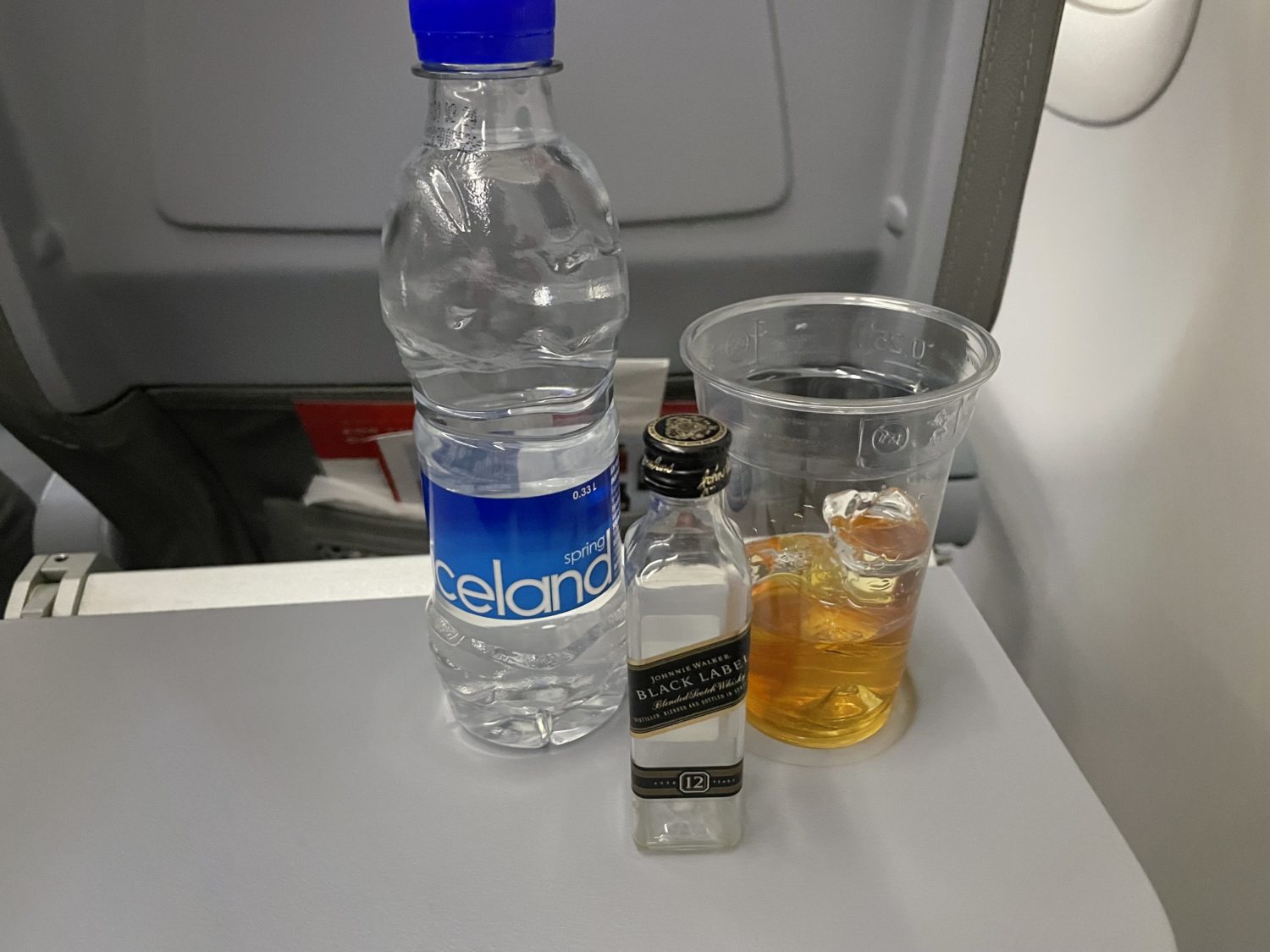 Whiskey and water on an airplane tray